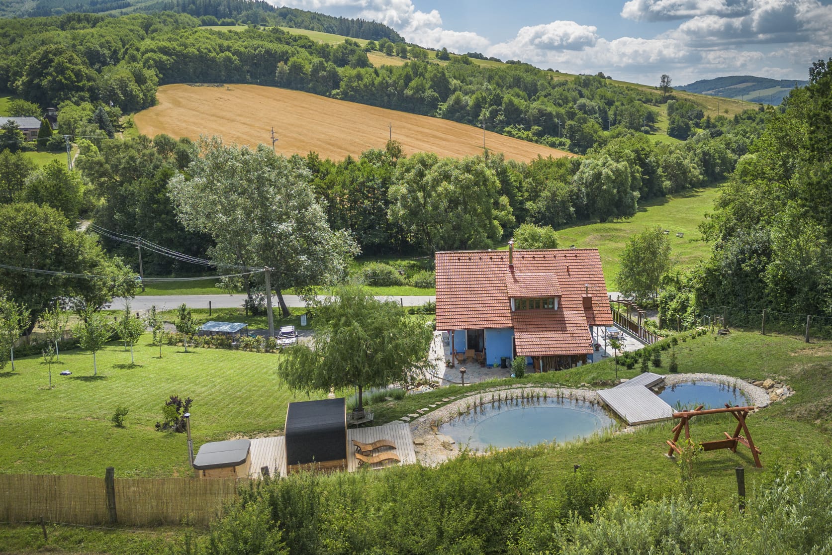 Pohled shora na chalupu, jezírka a wellness