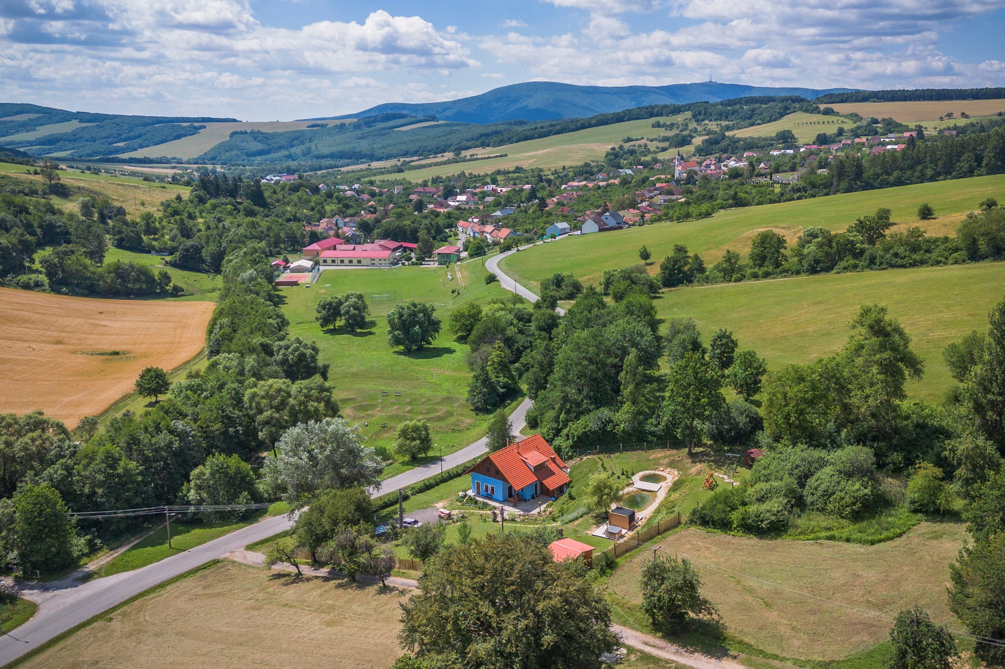 Údolí s vesnicí a hřebenem hor